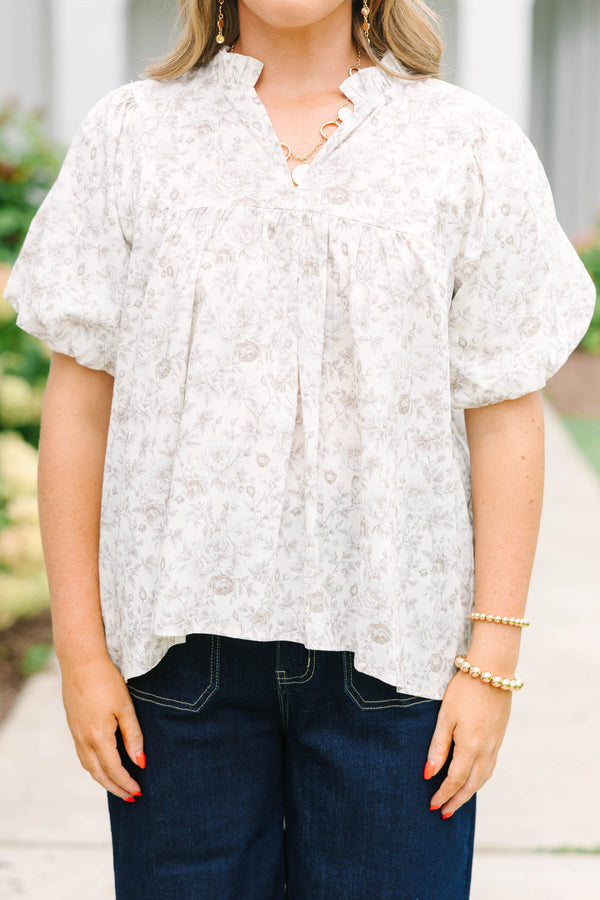 Plus Size cream floral blouse with a ruffled v-neckline and short elastic bubble sleeves.
