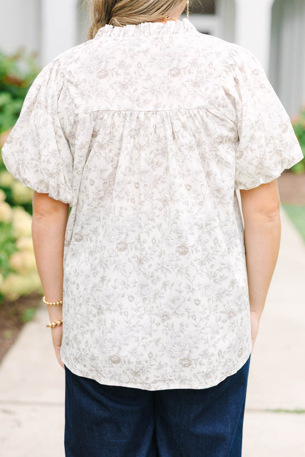Plus Size cream floral blouse with a ruffled v-neckline and short elastic bubble sleeves.