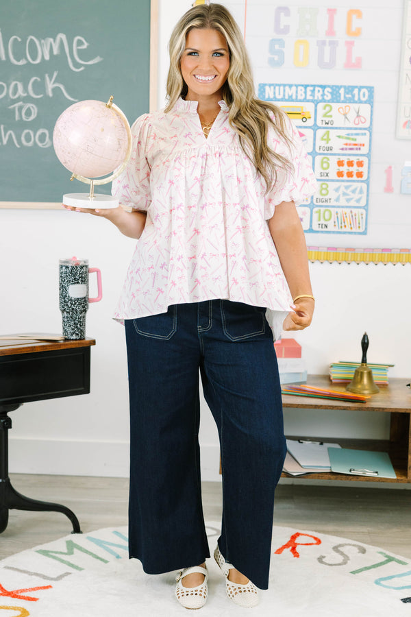 Plus Size pink and white blouse with pencil and bow print, ruffled v-neck, and bubble sleeves.