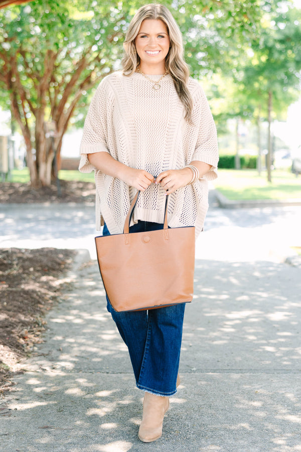 Plus size flowy oatmeal knit poncho sweater with a relaxed fit and textured stitch.