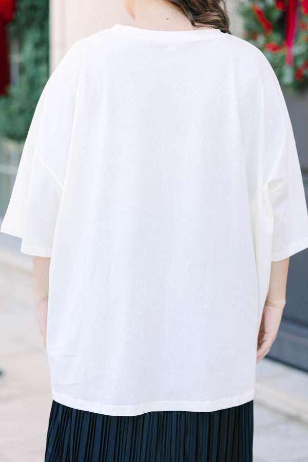 Plus Size ivory boyfriend tee with Christmas tree graphics and a black pleated skirt.