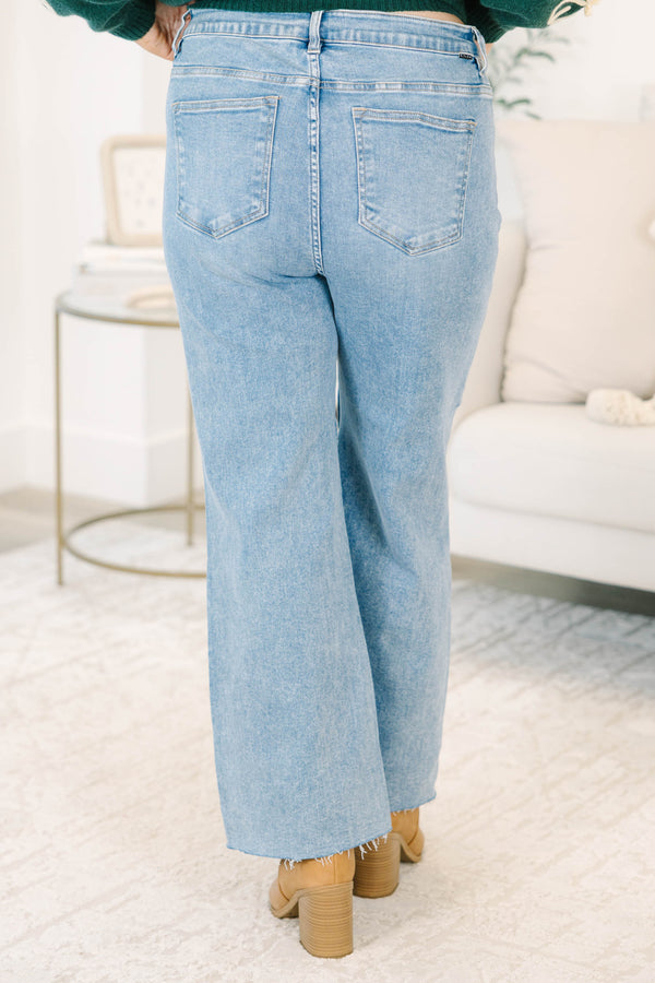 Plus Size medium wash wide-leg jeans with a high-rise fit and raw, frayed hems.