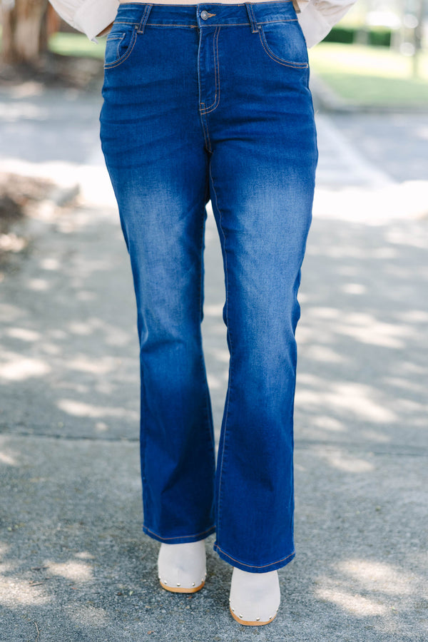 Plus Size dark wash flare jeans with a high-waisted fit and subtle fading on the thighs.