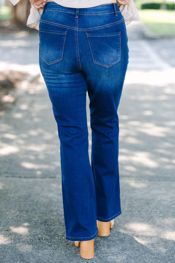Plus Size dark wash flare jeans with a high-waisted fit and subtle fading on the thighs.
