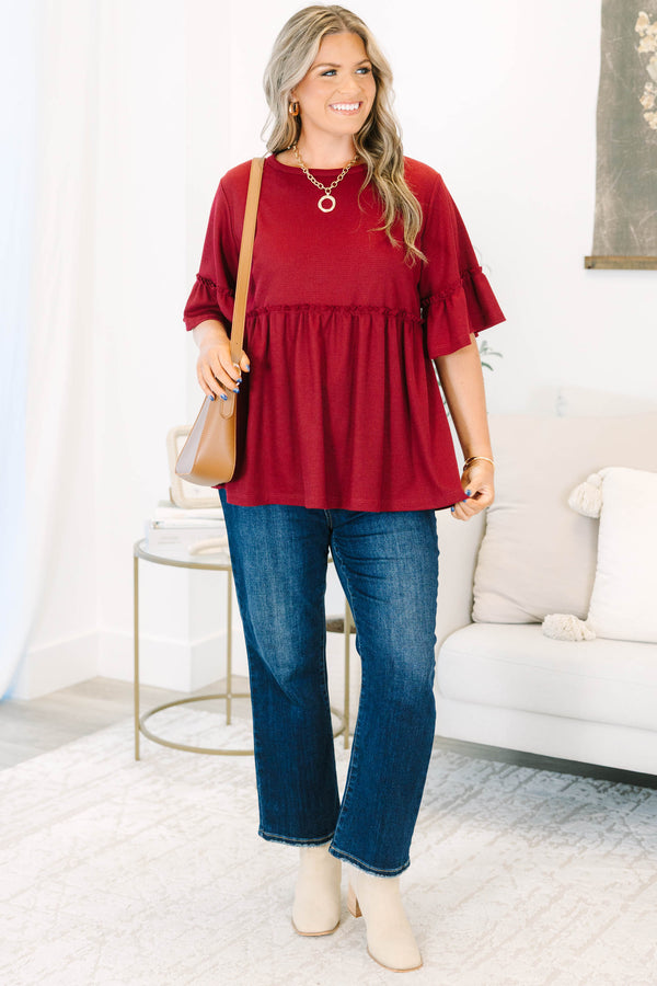 Plus Size burgundy waffle knit tunic with a round neck, ruffle sleeves, and a tiered babydoll fit.