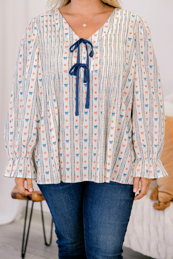 Chic Soul plus size clothing, white long sleeve top with a bow pattern and two bows going down the chest as well as ruffle details at the end of each sleeve 