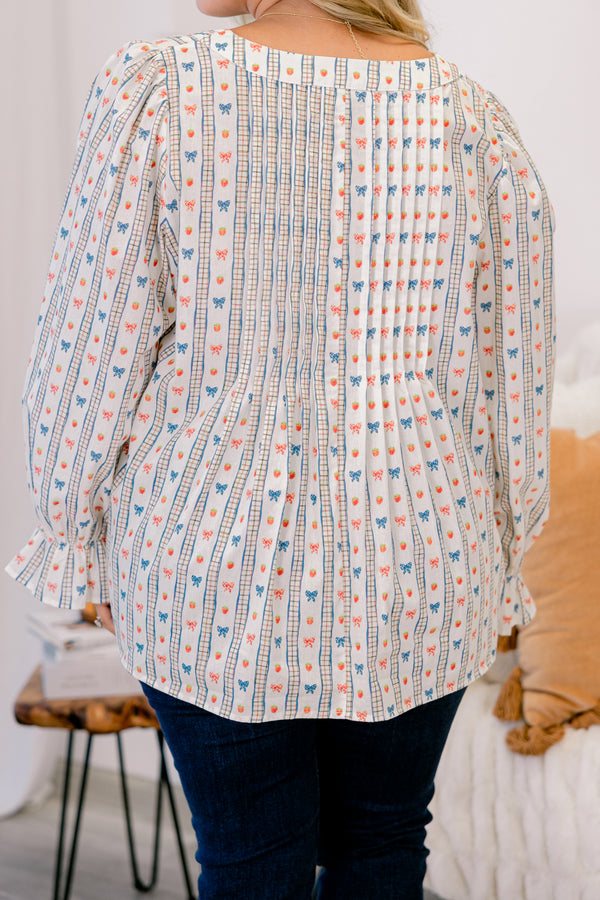 Chic Soul plus size clothing, white long sleeve top with a bow pattern and two bows going down the chest as well as ruffle details at the end of each sleeve 