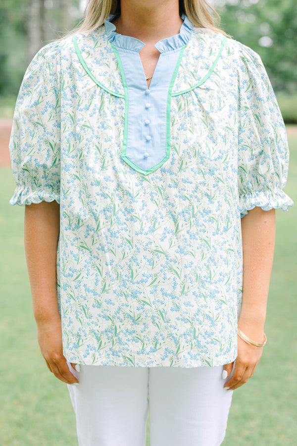 Plus Size blue floral top with a ruffled collar, buttoned bib, and short puff sleeves.