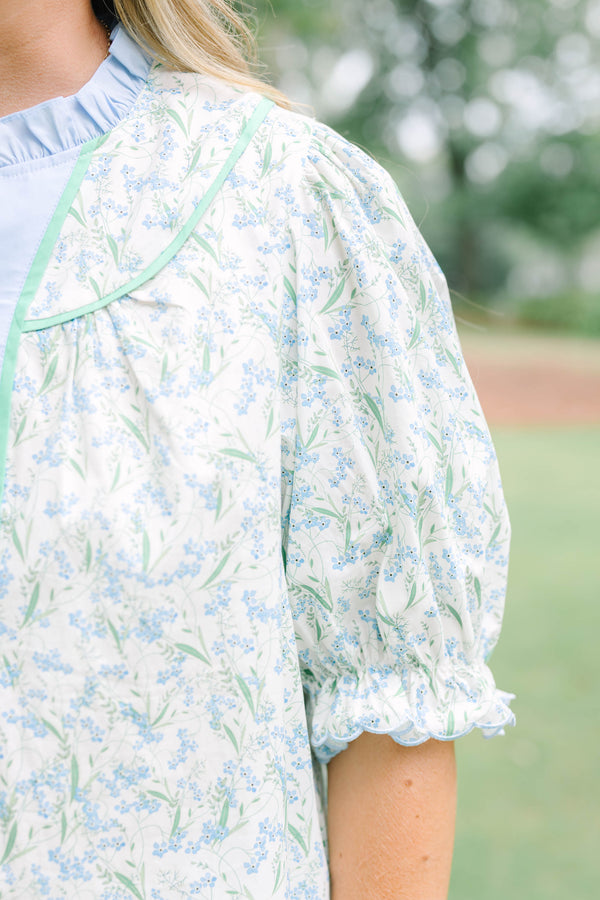 Plus Size blue floral top with a ruffled collar, buttoned bib, and short puff sleeves.