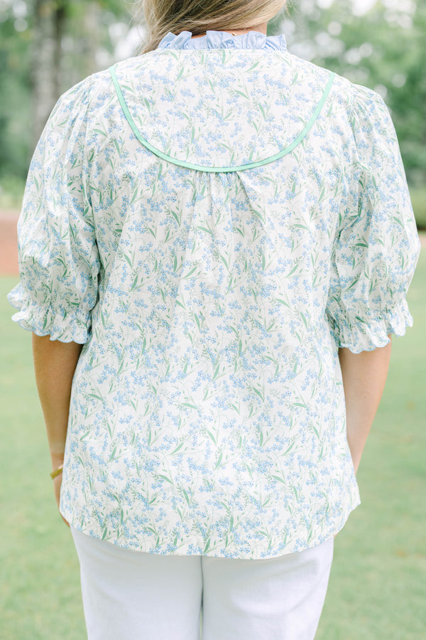 Plus Size blue floral top with a ruffled collar, buttoned bib, and short puff sleeves.