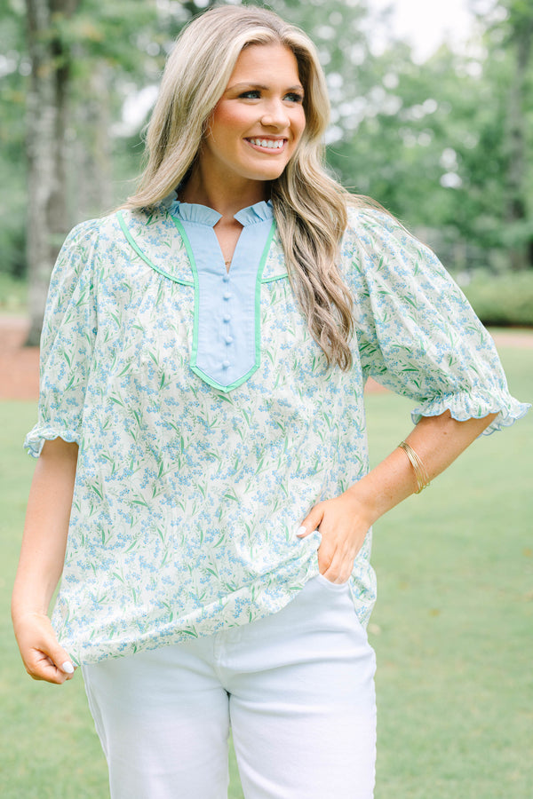 Plus Size blue floral top with a ruffled collar, buttoned bib, and short puff sleeves.