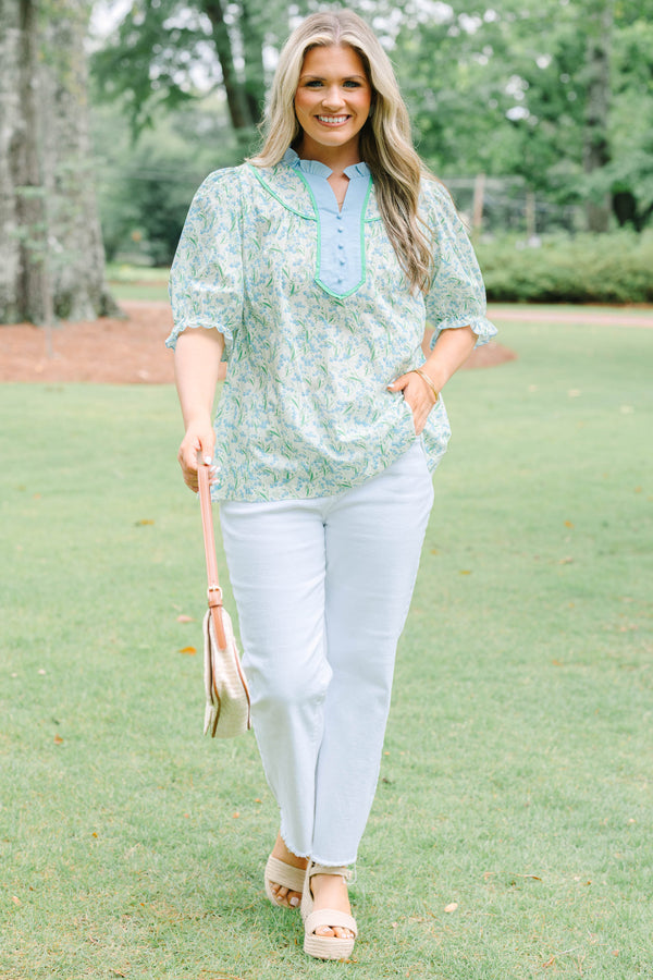 Plus Size blue floral top with a ruffled collar, buttoned bib, and short puff sleeves.
