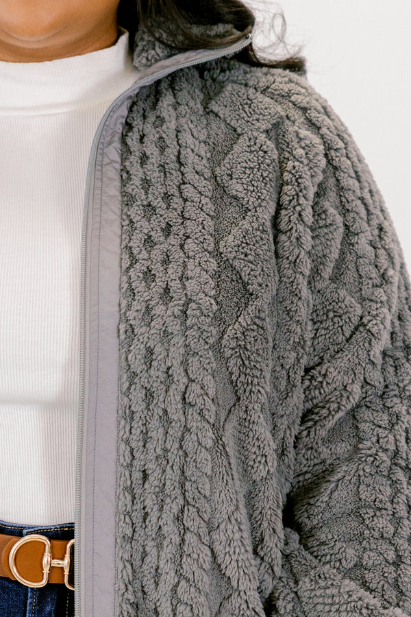 Close-up of a textured gray jacket with a white shirt underneath.