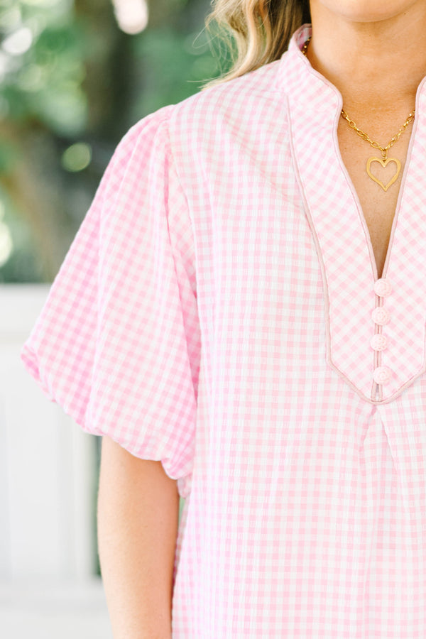 Plus size pink gingham top with puff sleeves and a v-neckline.