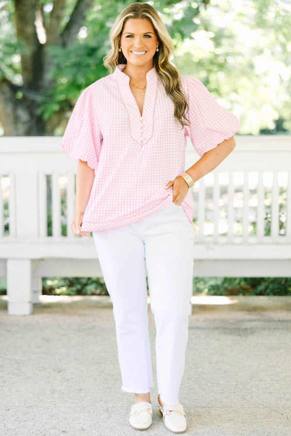 Plus size pink gingham top with puff sleeves and a v-neckline.