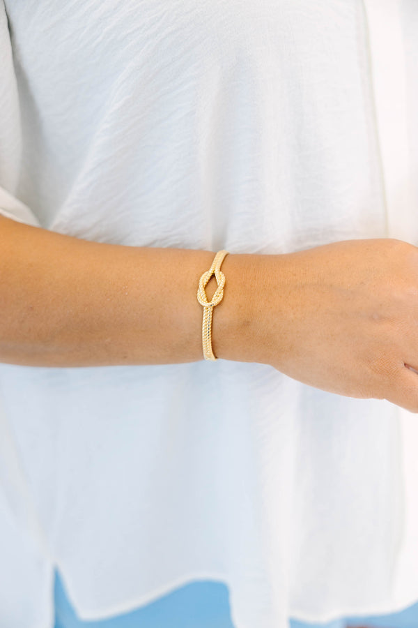 Plus Size gold bracelet with a twisted rope texture and a central knot design.