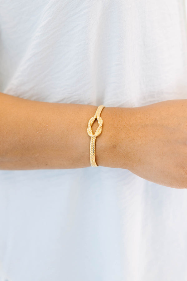 Plus Size gold bracelet with a twisted rope texture and a central knot design.