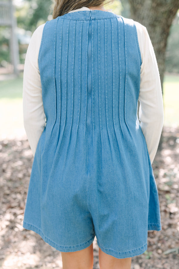 Plus Size denim romper with a tie-front V-neckline and pleated details over a white turtleneck.