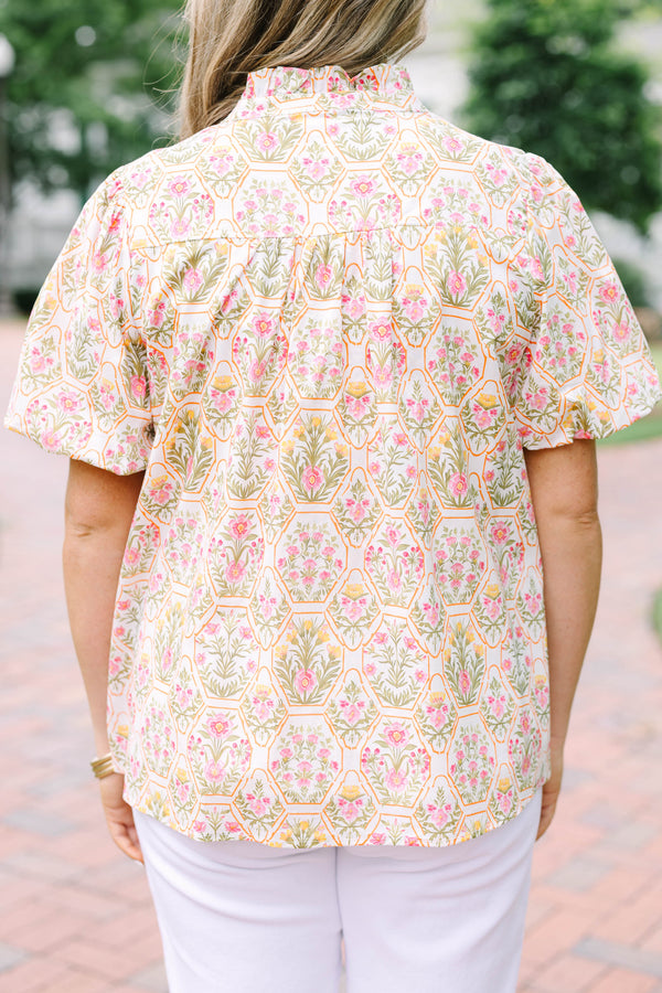 Plus Size pink floral print top with puff sleeves, a ruffled neckline, and tassel details.