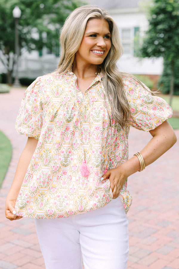 Plus Size pink floral print top with puff sleeves, a ruffled neckline, and tassel details.