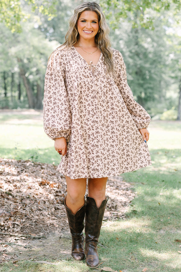 Plus size brown floral mini dress with a flowy fit, V-neck tie, and long puff sleeves.