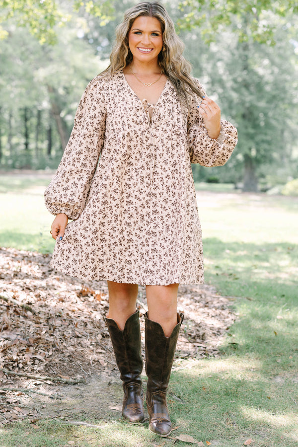 Plus size brown floral mini dress with a flowy fit, V-neck tie, and long puff sleeves.