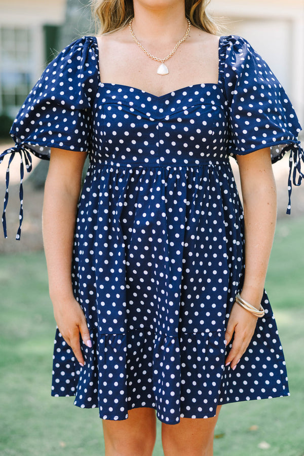 Plus Size navy blue polka dot cotton dress with puff sleeves, tie details, and a tiered skirt.