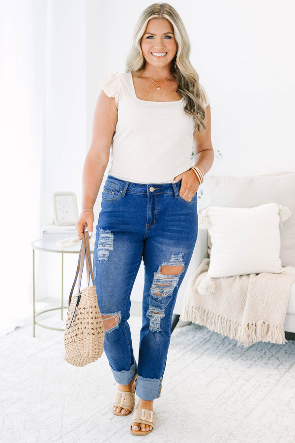 Plus size distressed denim jeans with a straight leg fit, frayed cuffs, and a medium wash.
