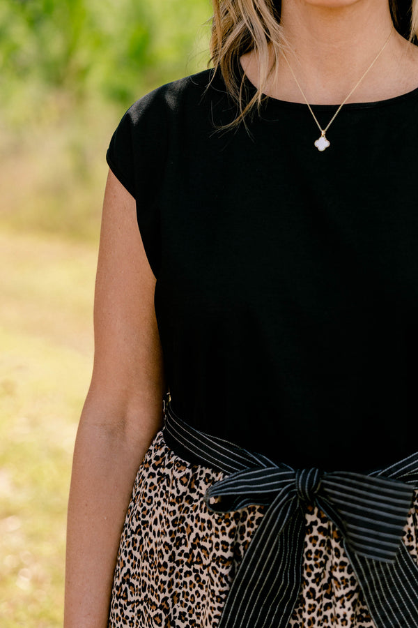 Chic Soul plus size clothing, maxi dress that has a shot sleeve solid black top and a leopard pattern tiered skirt that starts at the waistline as well as a bow that ties around the waist 