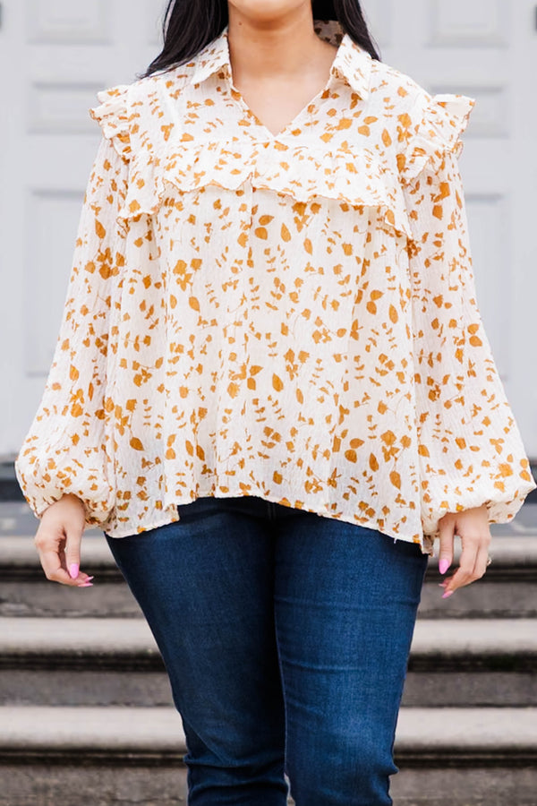 Chic Soul plus size clothing, white and orange patterned long sleeve top with v neckline and ruffle detailing and puff sleeves at the bottom