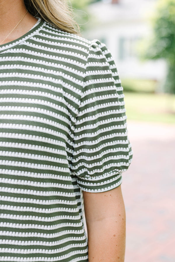 Plus size olive green top with white stitched stripes, puff sleeves, and a relaxed, flowy fit.