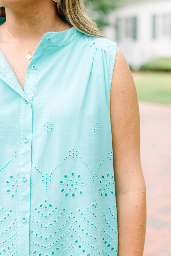 Plus Size turquoise sleeveless eyelet button-down top with a scalloped hem and white pants.