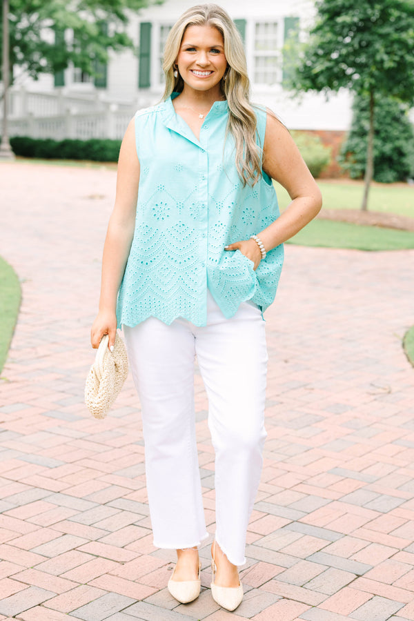 Plus Size turquoise sleeveless eyelet button-down top with a scalloped hem and white pants.