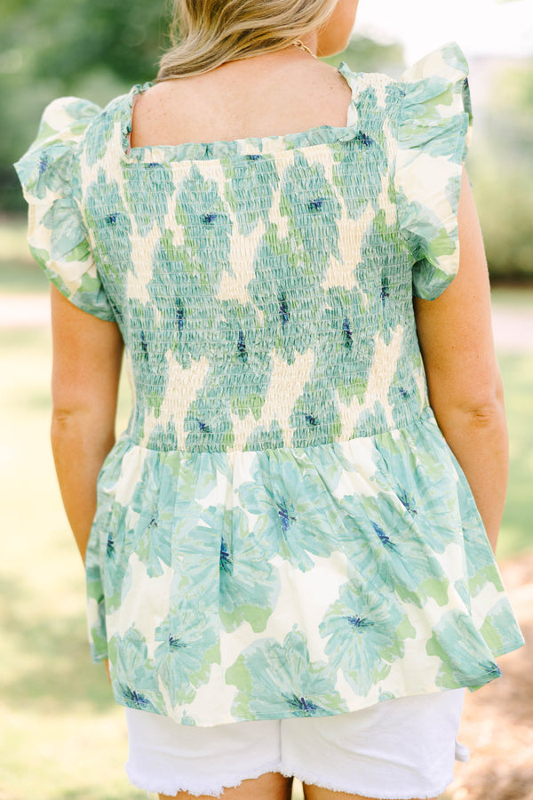 Plus size sea green floral smocked top with ruffle sleeves and a flowy peplum silhouette.