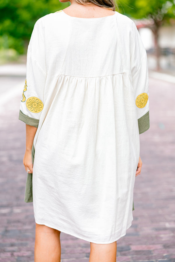 Chic Soul plus size clothing, white dress with half sleeves and olive accents on the ends of the sleeves and sides of the dress as well as a floral abstract pattern on the chest area and sleeves 