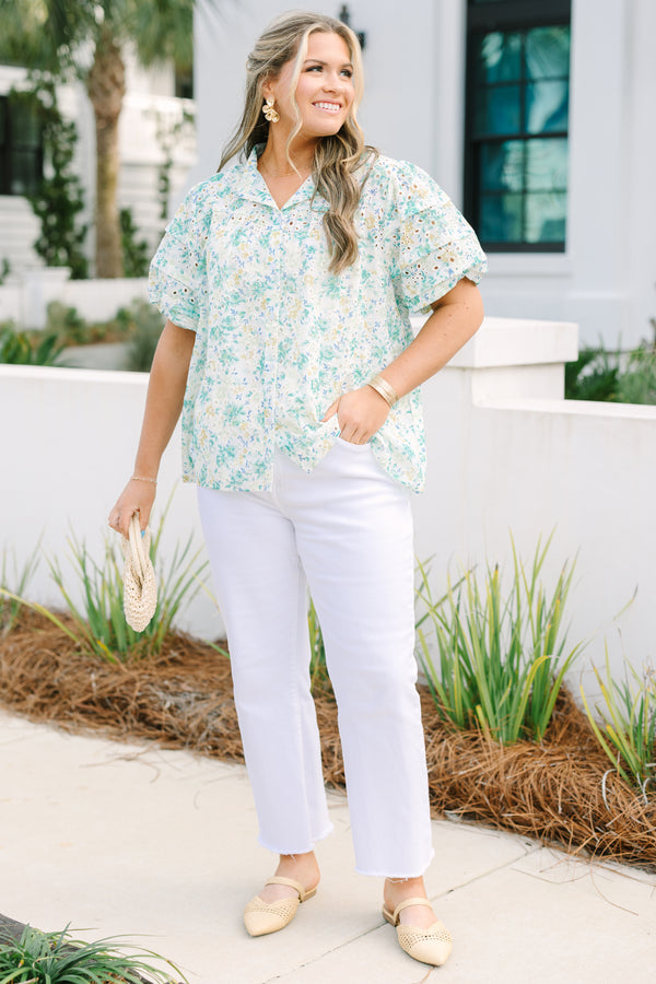 Chic Soul plus size clothing, white top with short sleeves that have eyelet detailing on the sleeves as well as a multi-color floral pattern throughout the top and buttons going down the center of the shirt 
