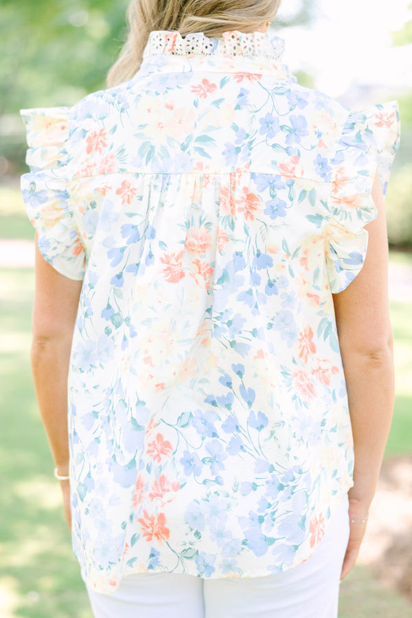 Plus Size white floral top with ruffle cap sleeves, a lace-trimmed collar, and white pants.