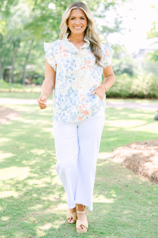 Plus Size white floral top with ruffle cap sleeves, a lace-trimmed collar, and white pants.