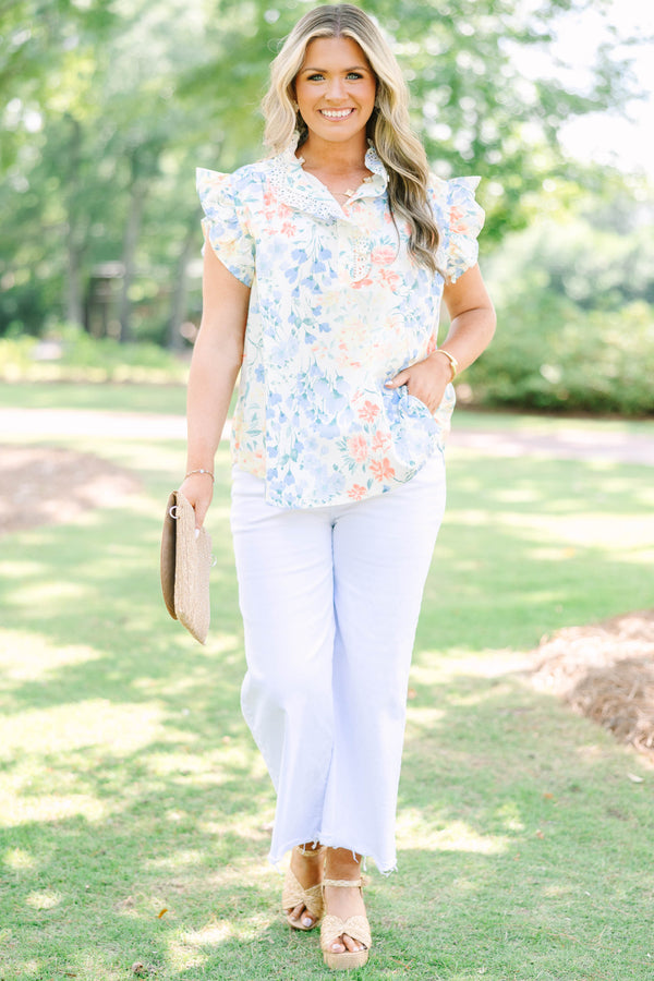 Plus Size white floral top with ruffle cap sleeves, a lace-trimmed collar, and white pants.