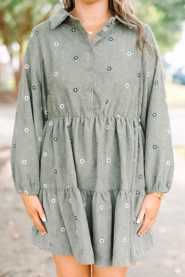 Plus size olive green corduroy babydoll dress with white floral embroidery and button-up front.