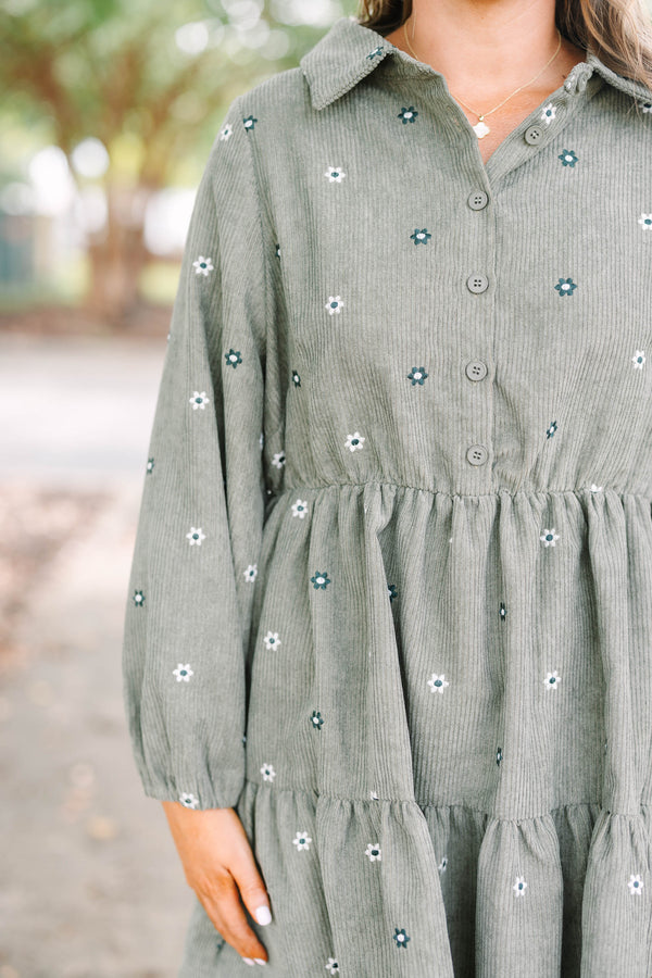 Plus size olive green corduroy babydoll dress with white floral embroidery and button-up front.