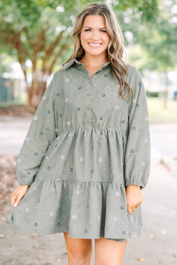 Plus size olive green corduroy babydoll dress with white floral embroidery and button-up front.