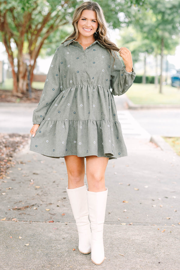 Plus size olive green corduroy babydoll dress with white floral embroidery and button-up front.
