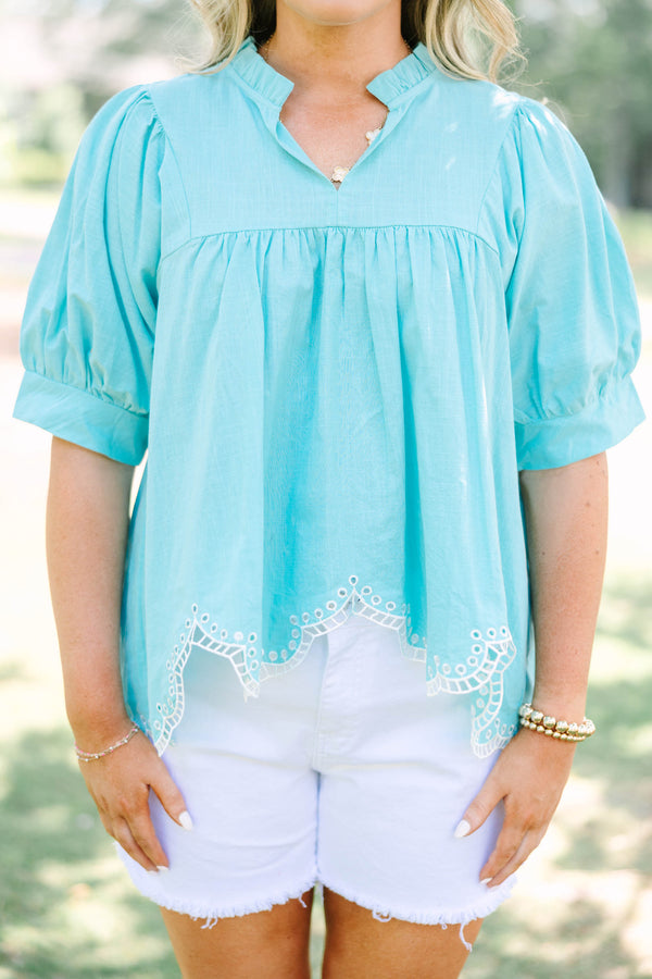 Plus Size turquoise cotton top with puff sleeves, a ruffled bodice, and white eyelet hem detailing.
