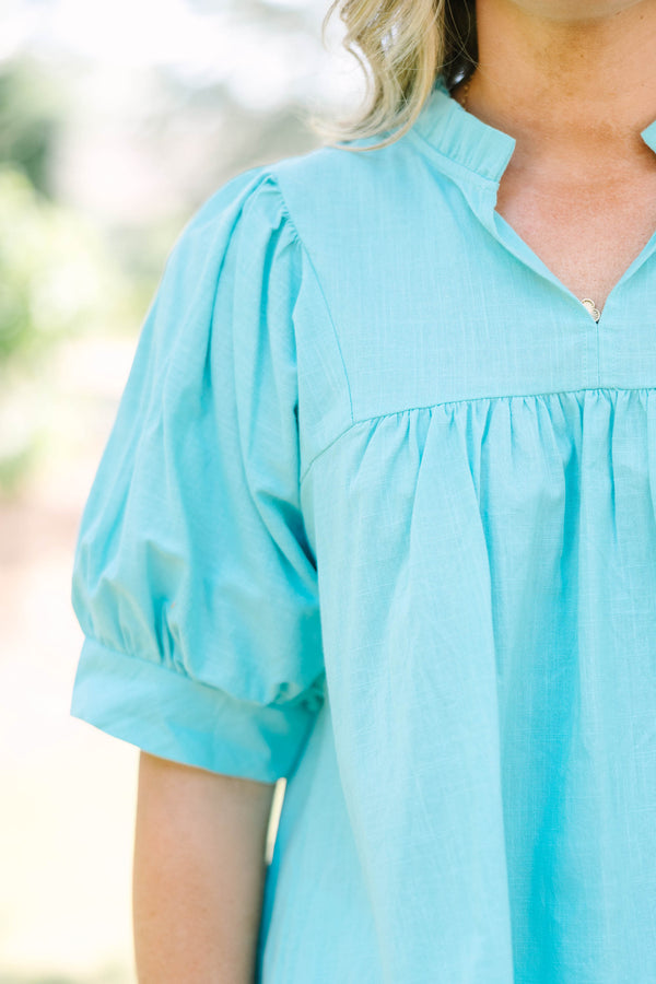 Plus Size turquoise cotton top with puff sleeves, a ruffled bodice, and white eyelet hem detailing.