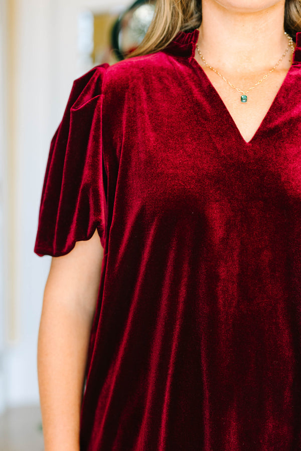 Plus size wine red velvet top with a V-neckline and flowy short sleeves for a festive holiday look.