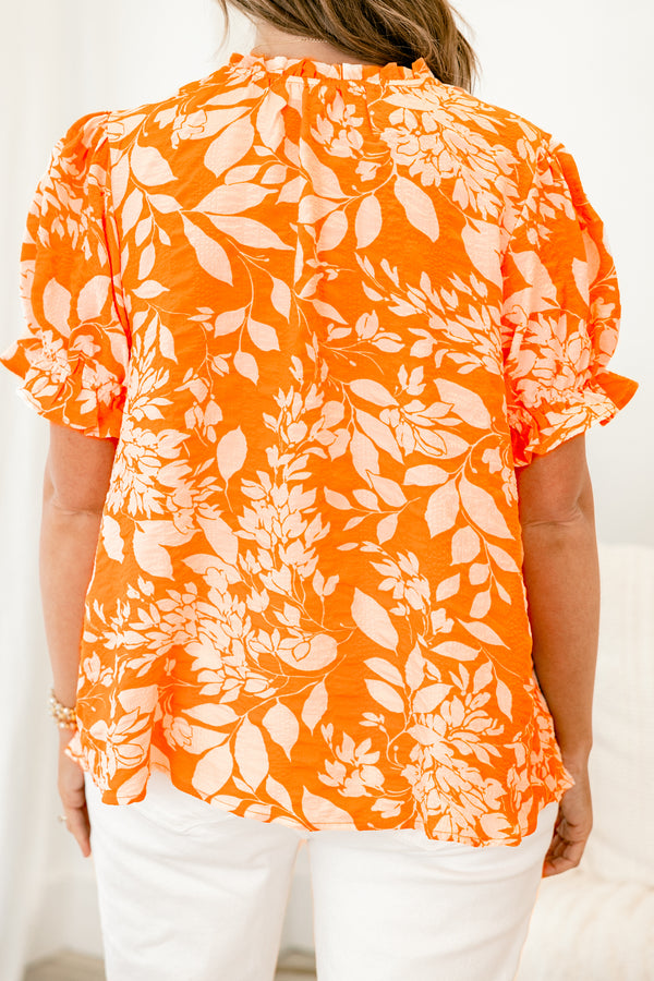 Chic Soul plus size clothing, orange top with a white floral pattern and bubble sleeves that have small ruffle detailing on the ends 