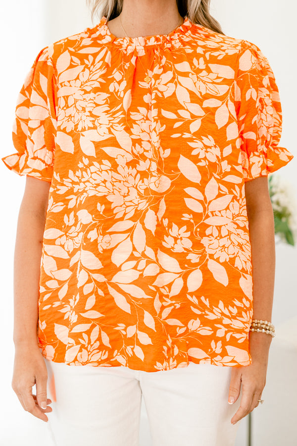 Chic Soul plus size clothing, orange top with a white floral pattern and bubble sleeves that have small ruffle detailing on the ends 