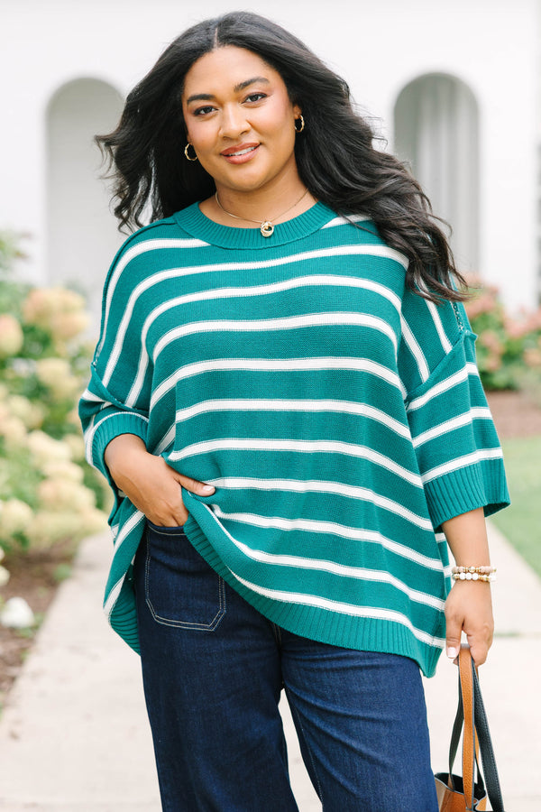 Plus size woman in a green and white striped, oversized knit sweater with a flowy, relaxed fit.