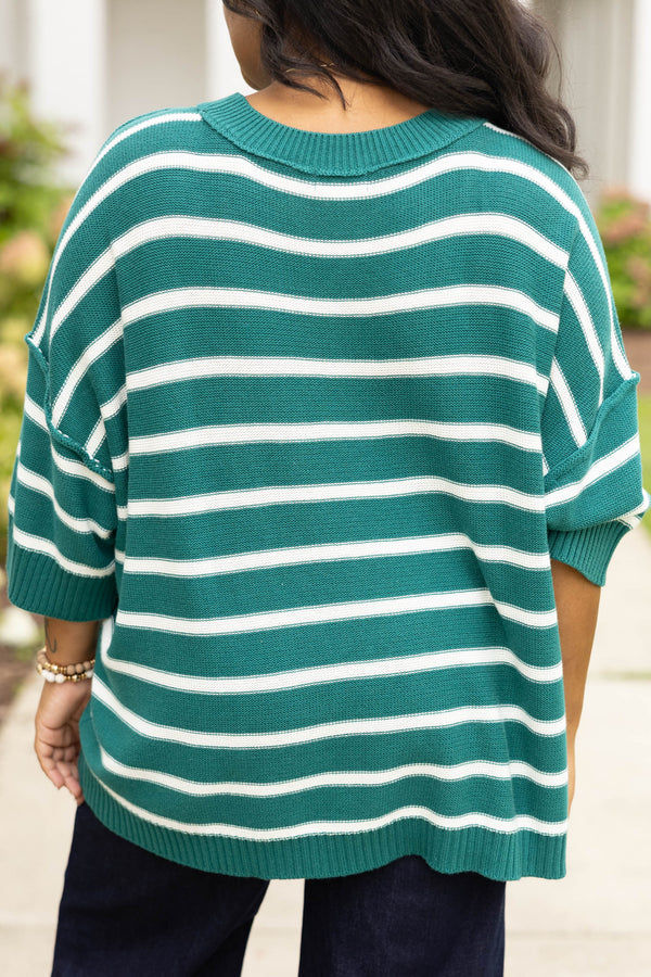 Plus size green and white striped, oversized knit sweater with a flowy, relaxed fit.